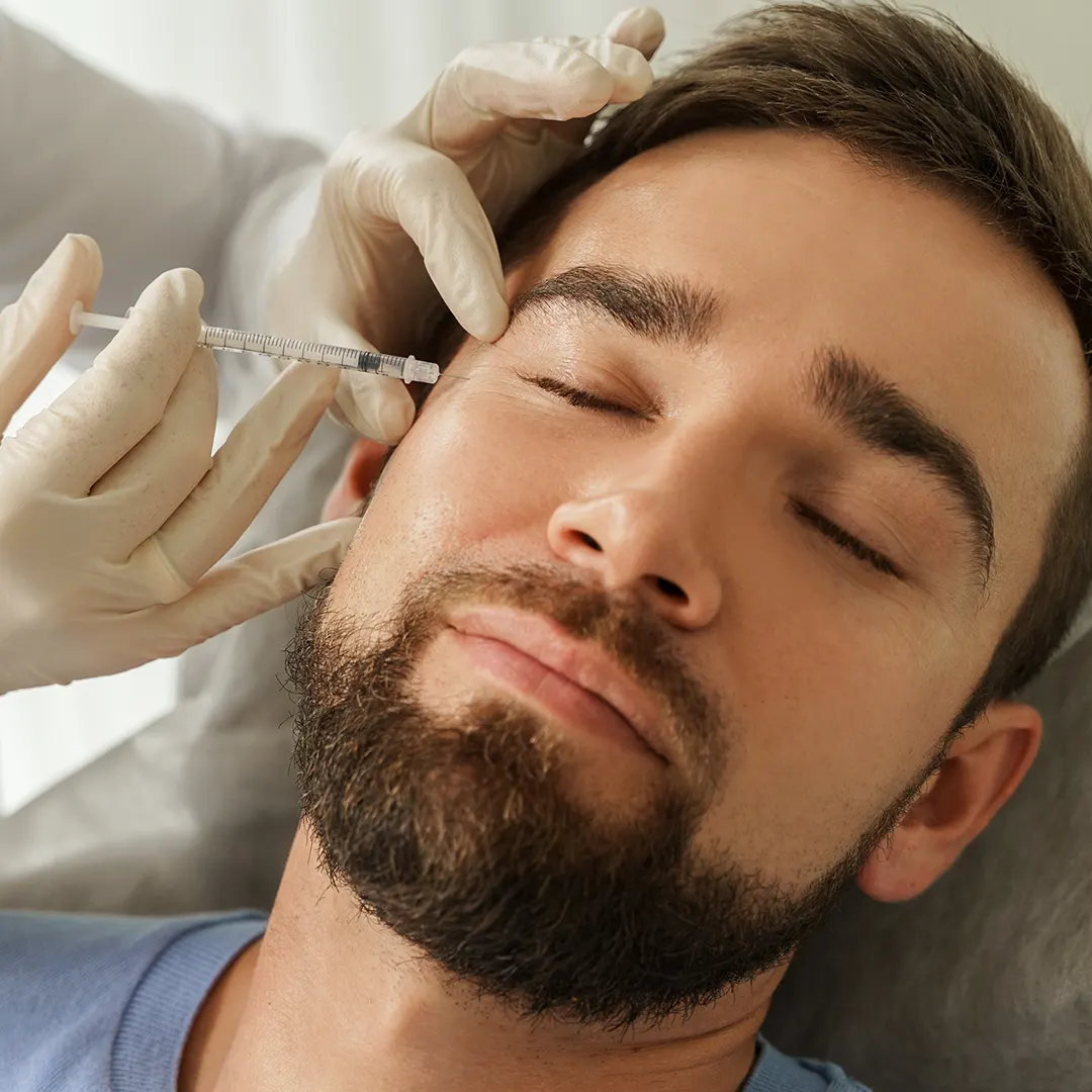 hombre recibiendo inyección de botox en la ceja