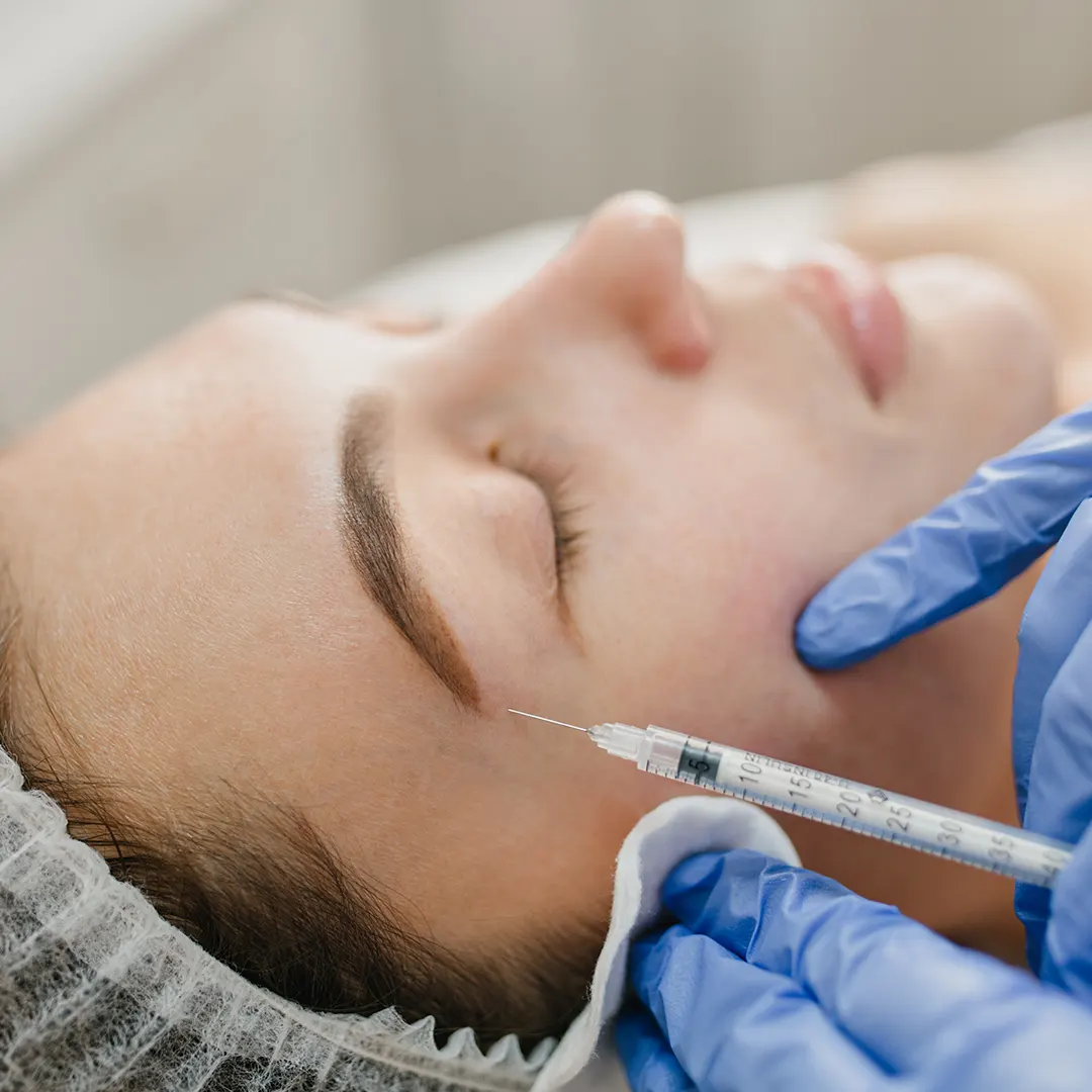 mujer recibiendo inyección de botox en la ceja