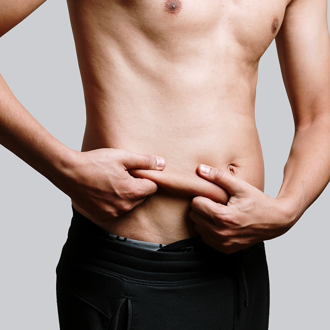 hombre agarrando grasa extra de su abdomen